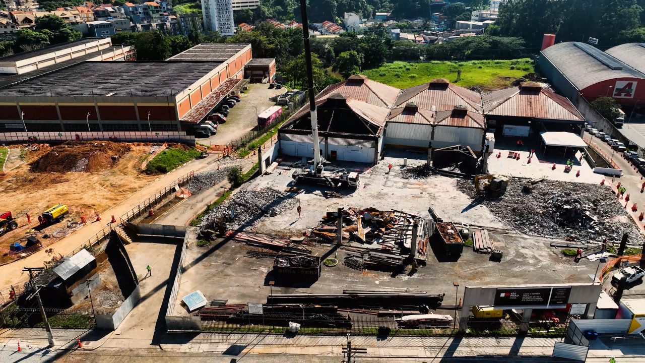 Vista aérea das obras de ampliação da Linha 4-Amarela com demolição de estruturas e preparação do terreno.