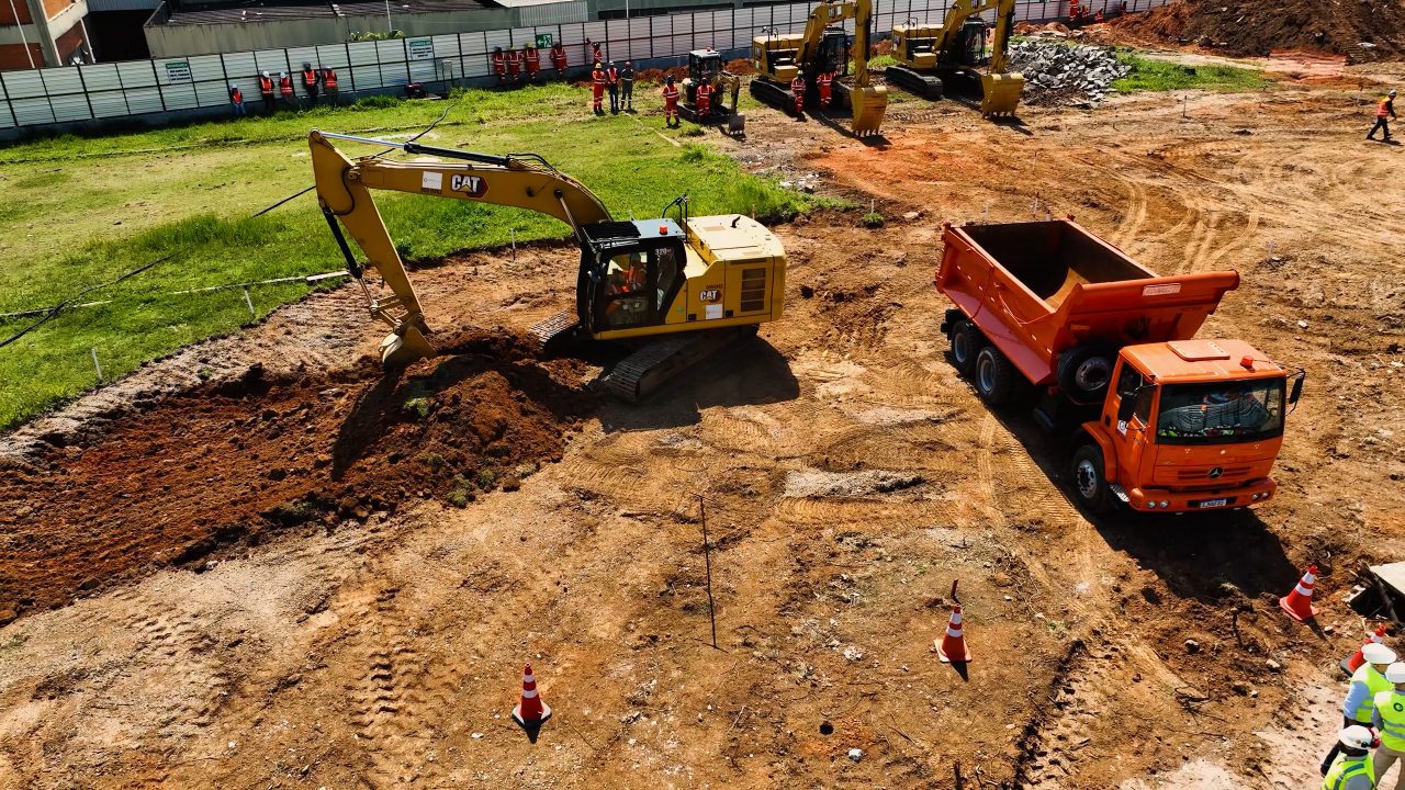 Escavadeira e caminhão atuando na movimentação de terra durante avanço das obras da Linha 4-Amarela.