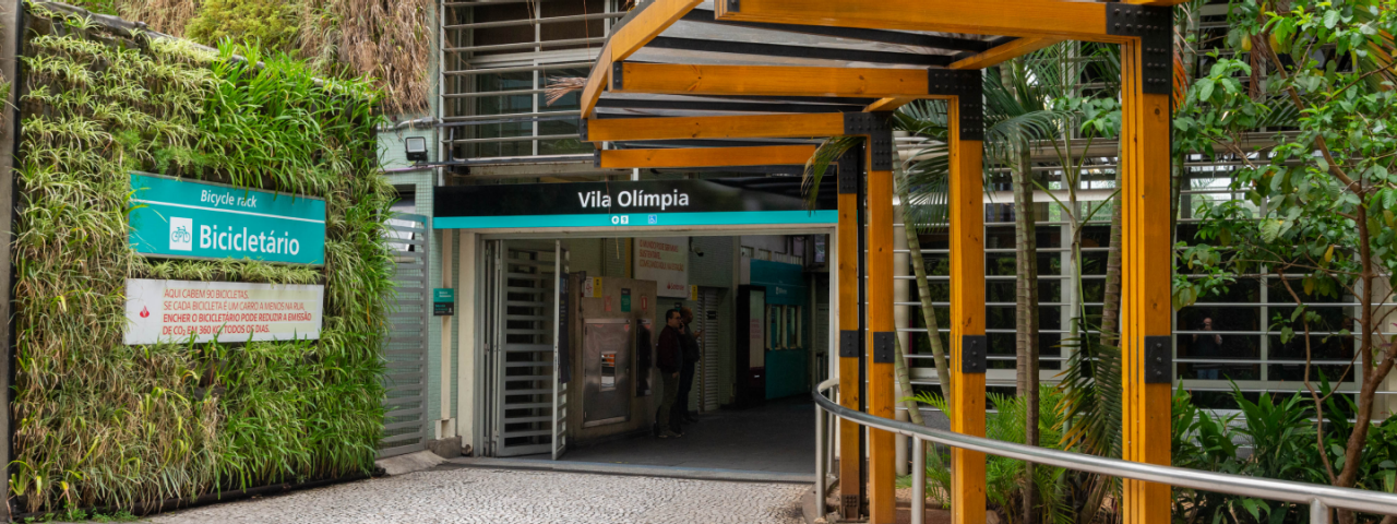 A imagem mostra a entrada da Estação Vila Olímpia da CPTM, em São Paulo, com destaque para o bicicletário.